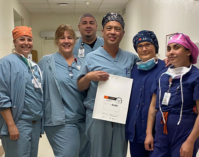 Medical staff holding certificate in hallway